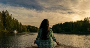 Women doing yoga on lakeside