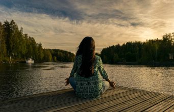Women doing yoga on lakeside