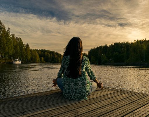 Women doing yoga on lakeside