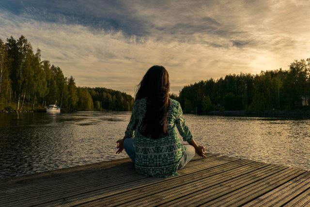 Women doing yoga on lakeside